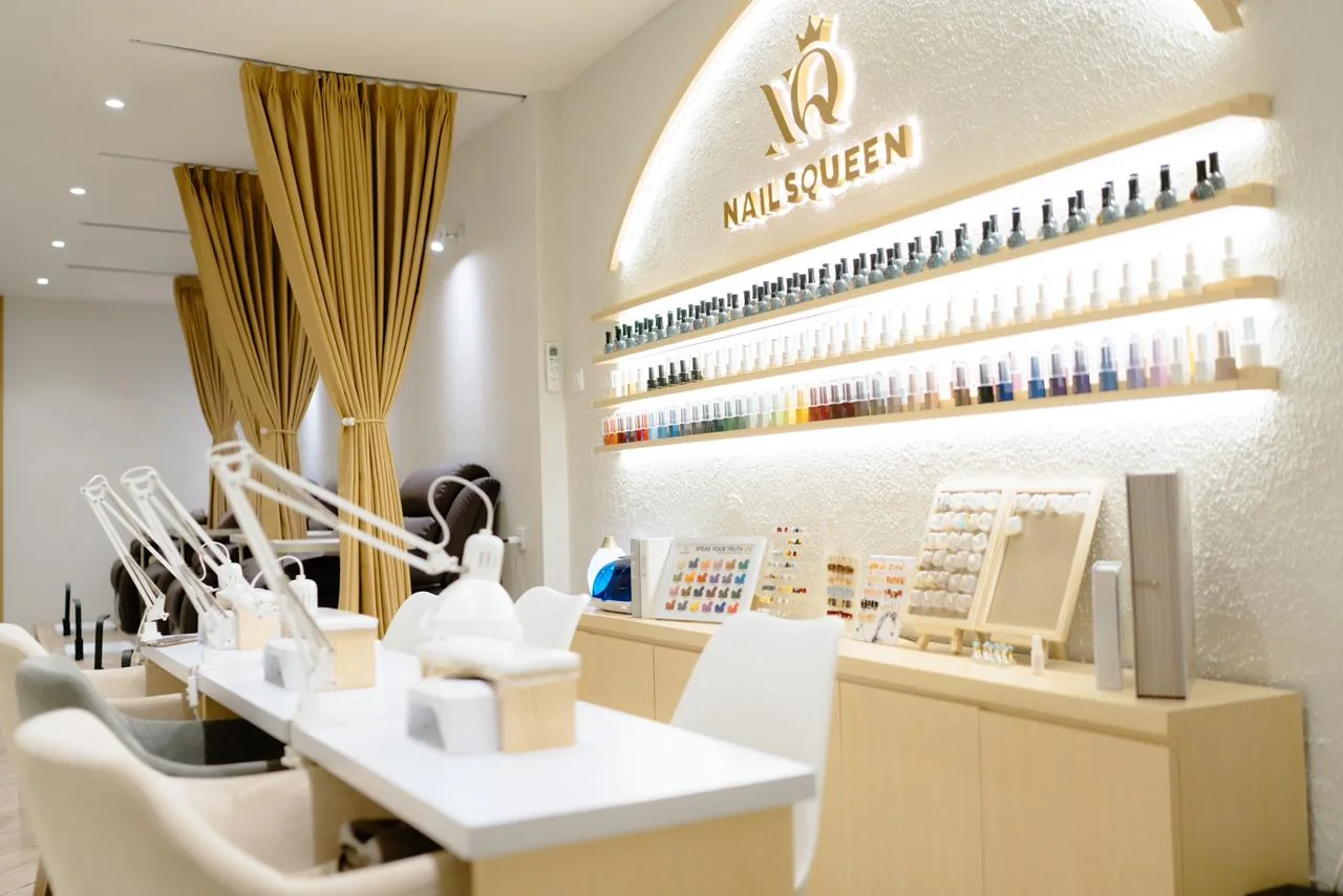 Interior asli studio Nails Squeen di Cilegon dengan meja manicure, kursi nyaman, tirai keemasan, dan rak warna nail polish
